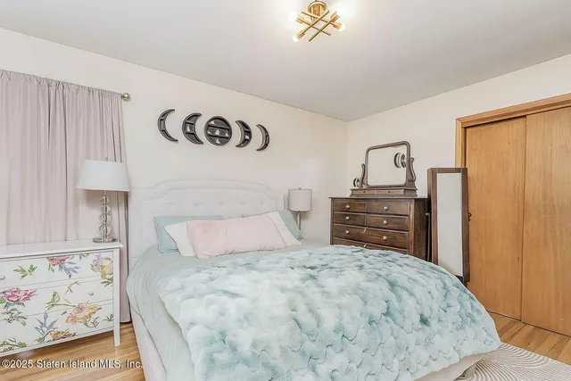 a bedroom with a bed and a painting on the wall