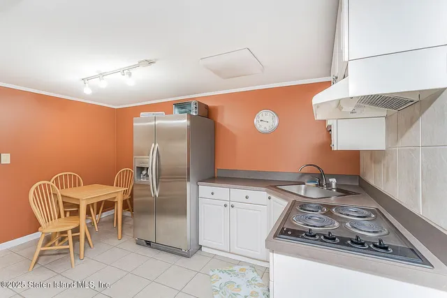 a kitchen with stainless steel appliances granite countertop a stove a refrigerator and a dining table