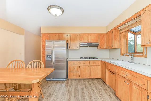 a kitchen with stainless steel appliances granite countertop a sink a stove and a refrigerator