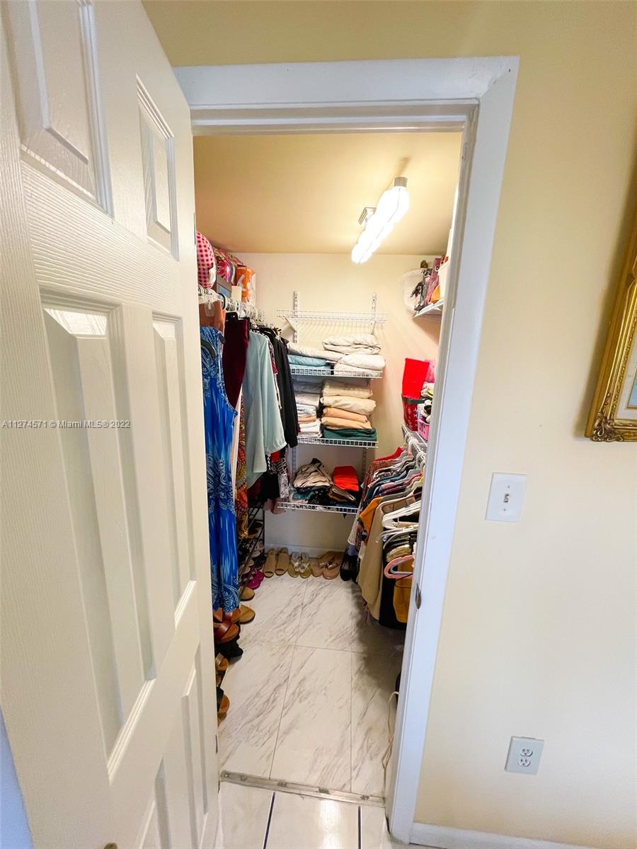 2811 North Pine Island Road, Unit 111 Sunrise, FL 33322 - Photo 14 of 16 a view of walk in closet with clothes and shoes