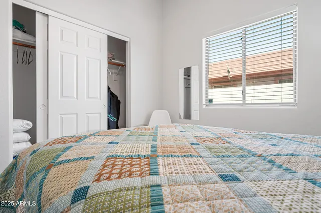 a bedroom with a bed and a flat tv screen on dresser