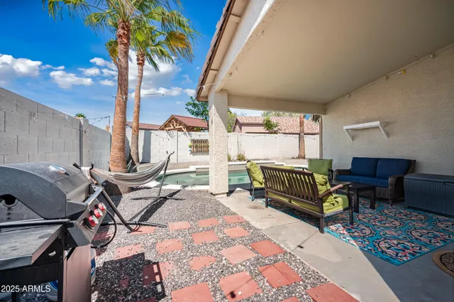 a view of a house with backyard sitting area and swimming pool