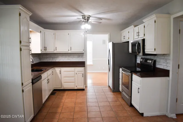 a kitchen with white cabinets and white appliances
