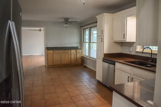 a kitchen with granite countertop a sink a stove and cabinets