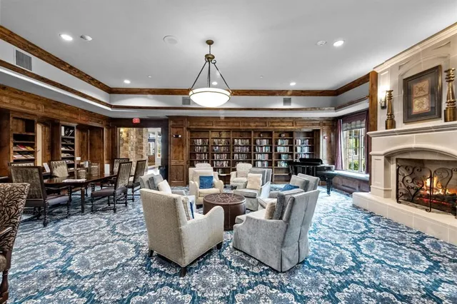 a living room with furniture a fireplace and a large window