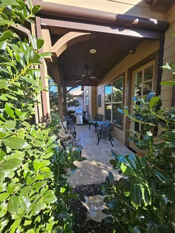 a view of patio with table and chairs and potted plants