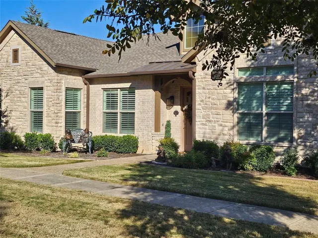 a front view of a house with a yard and potted plants