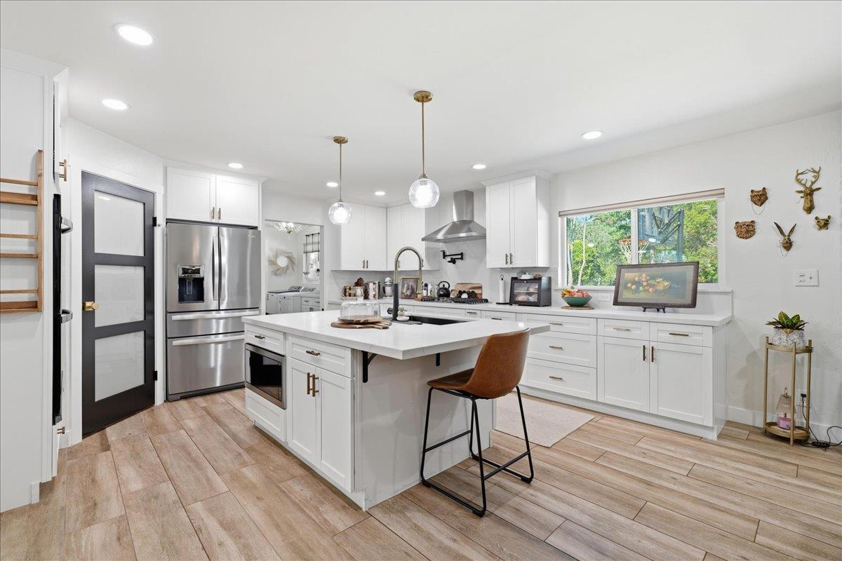 4849 Alexon Way Carmichael, CA 95608 - Photo 2 of 50 a kitchen with stainless steel appliances granite countertop a sink a stove a refrigerator and island with wooden floor