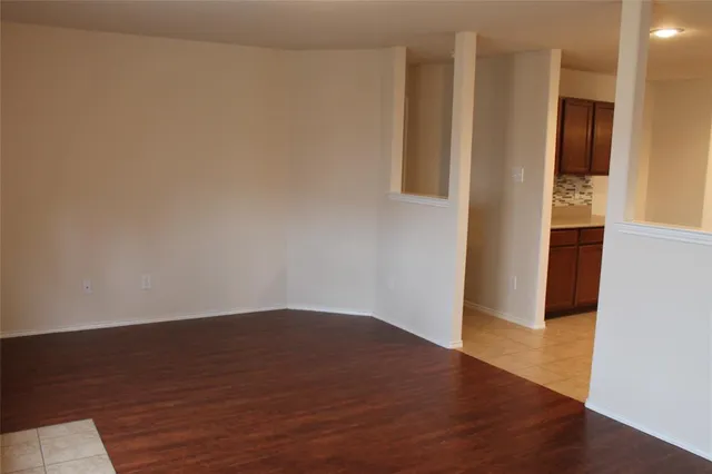 a view of an empty room with wooden floor and closet