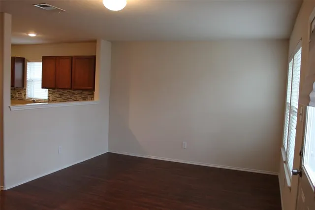 an empty room with wooden floor and a window
