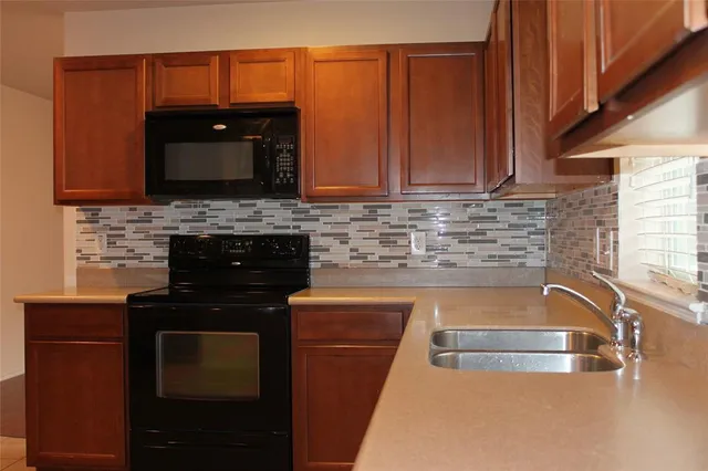 a kitchen with granite countertop a sink and a stove top oven