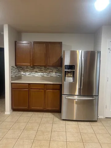a kitchen with granite countertop a refrigerator and a sink