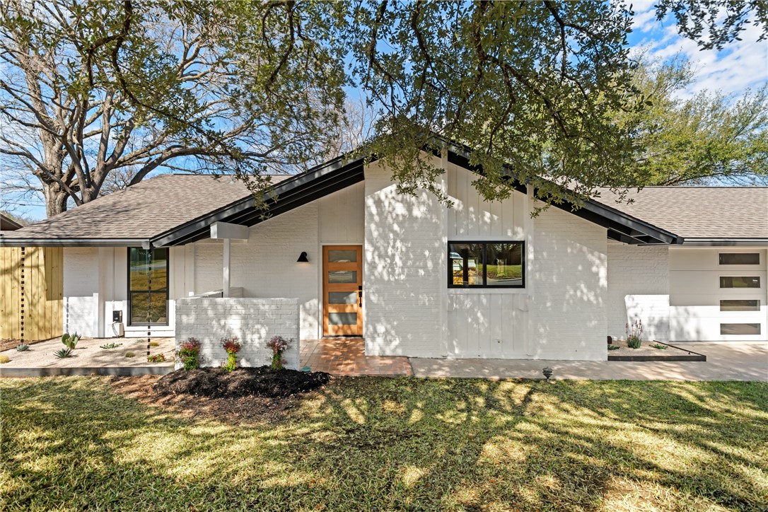 a front view of a house with a yard garage and outdoor seating