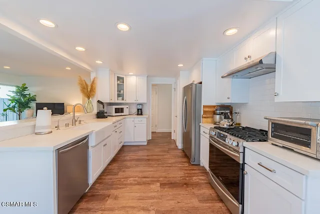 a large kitchen with stainless steel appliances lots of counter space and a sink