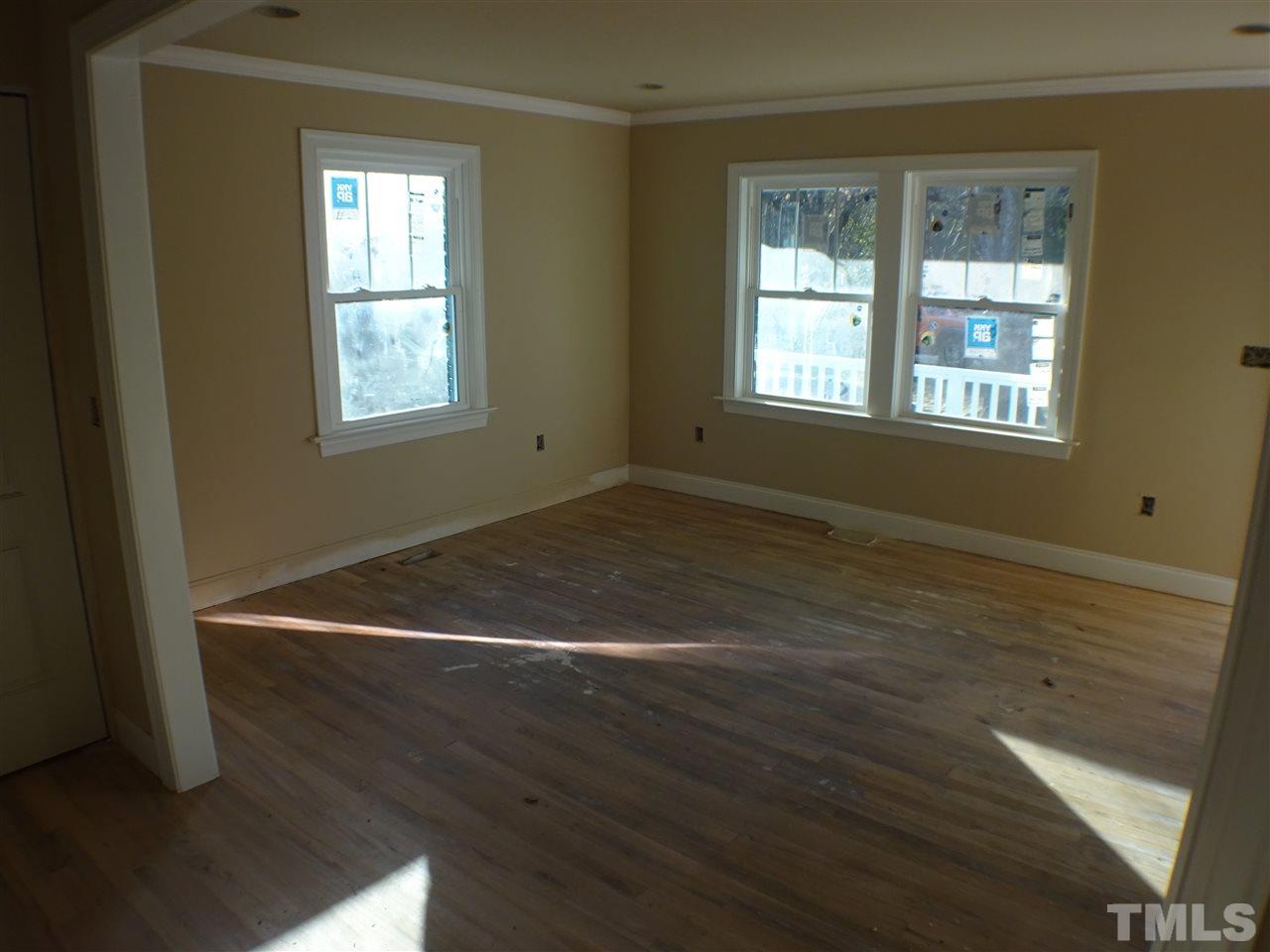 427 Lamont Street Raleigh, NC 27610 - Photo 6 of 13 an empty room with wooden floor and windows