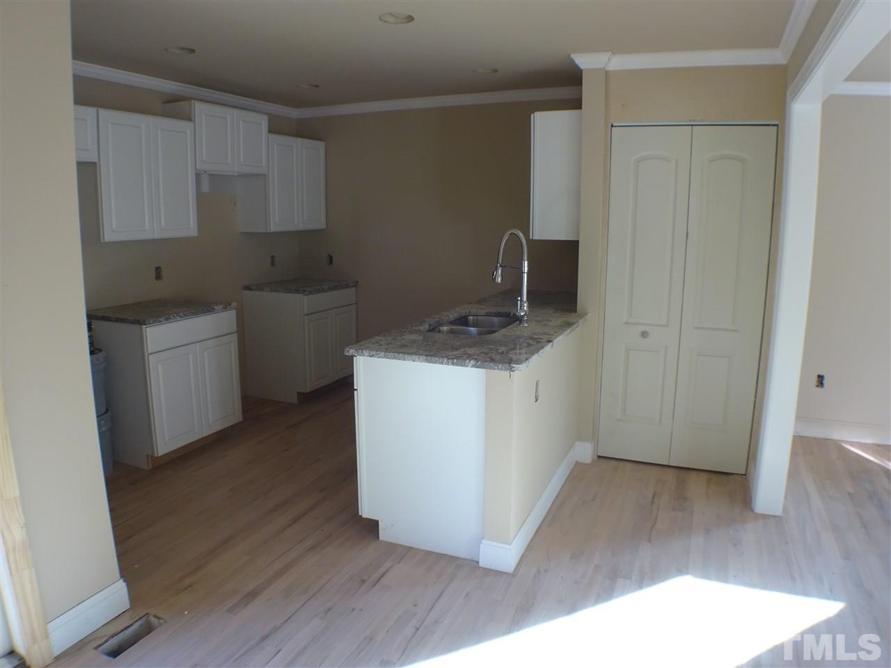 427 Lamont Street Raleigh, NC 27610 - Photo 8 of 13 a room with wooden floor and white cabinets
