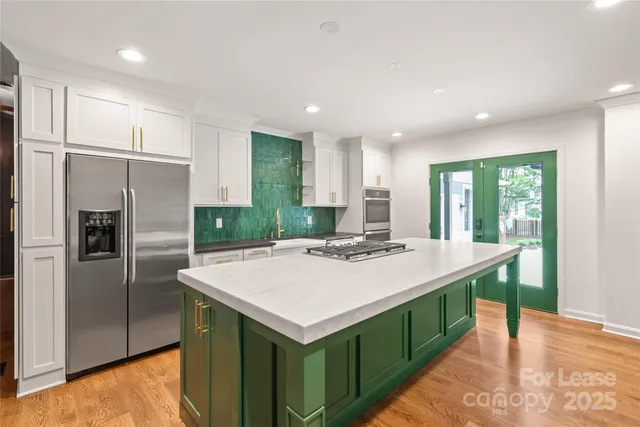 a kitchen with a refrigerator a sink and a stove top oven