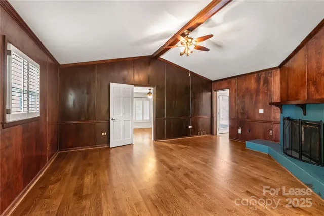 a view of a livingroom with wooden floor and staircase