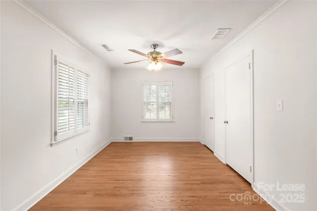a view of an empty room with a window and a ceiling fan