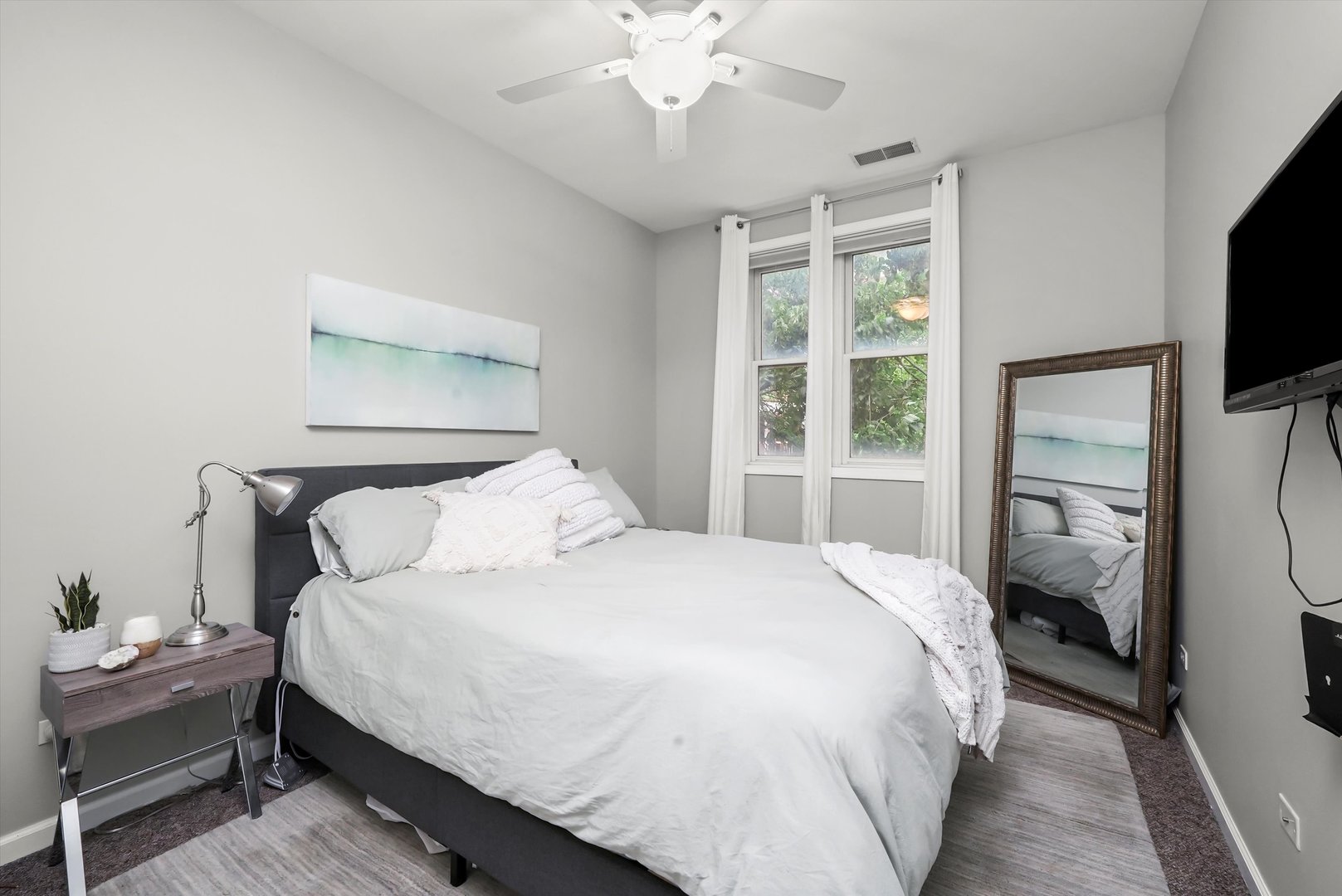 1535 West Ohio Street, Unit 2 Chicago, IL 60642 - Photo 18 of 25 a bedroom with a large bed and a flat tv screen on a dresser