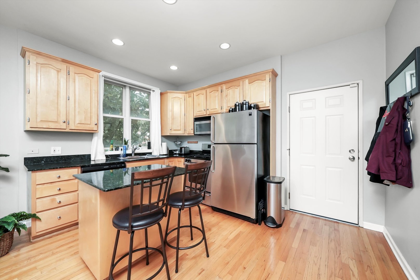1535 West Ohio Street, Unit 2 Chicago, IL 60642 - Photo 6 of 25 a kitchen with stainless steel appliances granite countertop a refrigerator a stove a sink dishwasher and a dining table with wooden floor