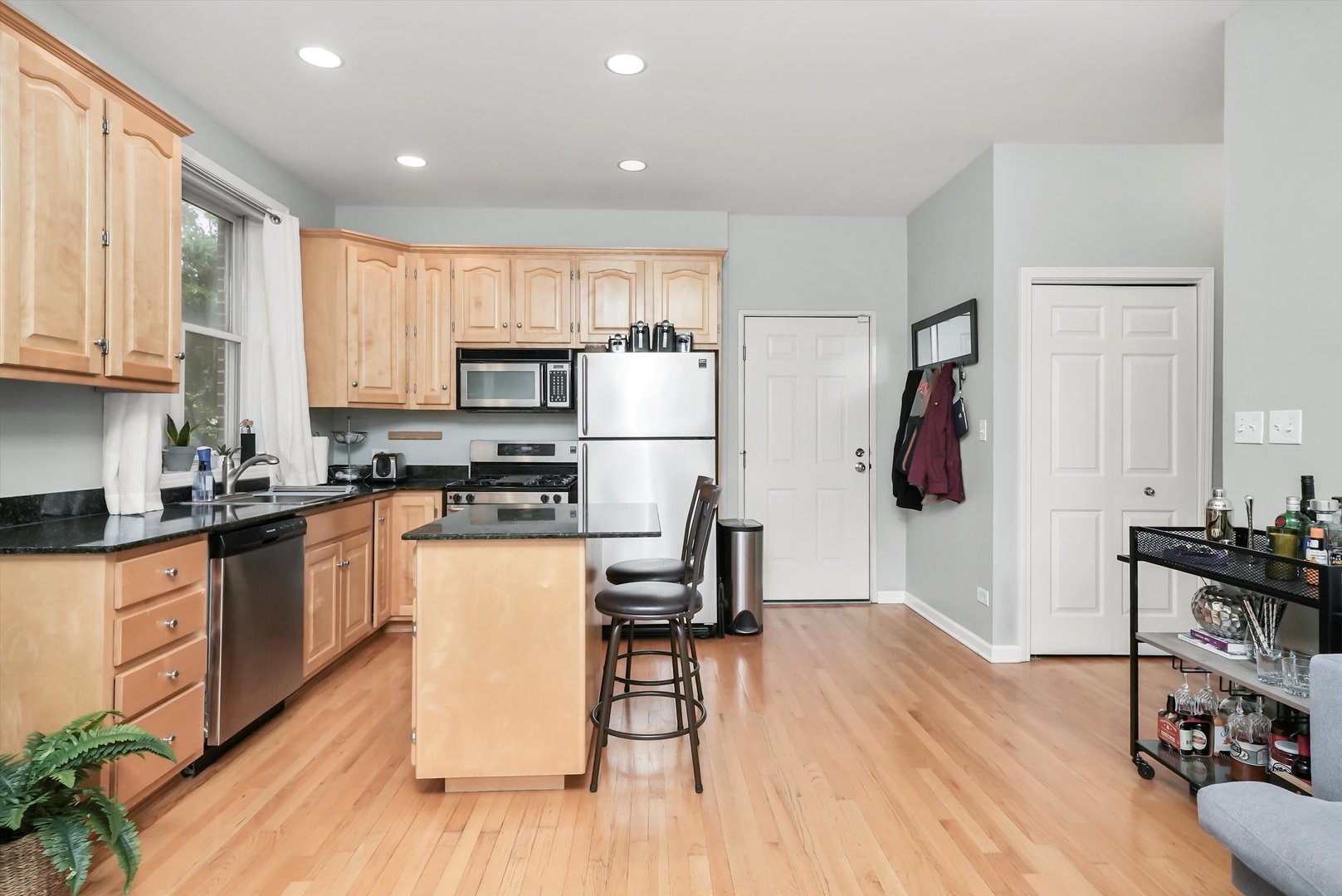 1535 West Ohio Street, Unit 2 Chicago, IL 60642 - Photo 7 of 25 a kitchen with granite countertop a refrigerator stove and wooden floor
