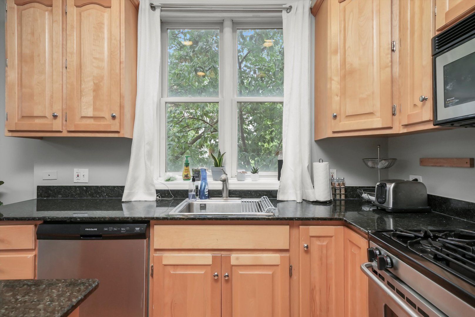 1535 West Ohio Street, Unit 2 Chicago, IL 60642 - Photo 8 of 25 a kitchen with granite countertop stainless steel appliances white cabinets and a window