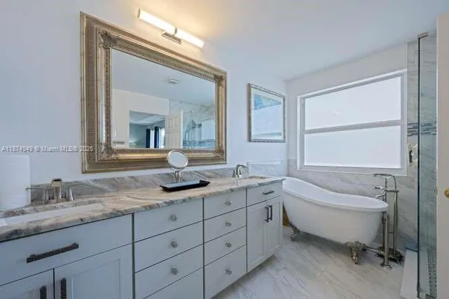 a bathroom with a granite countertop sink mirror and bathtub