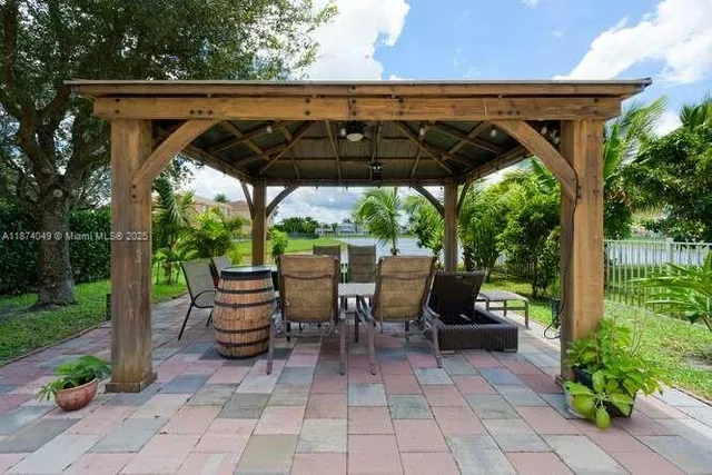 a view of patio with table and chairs under an umbrella