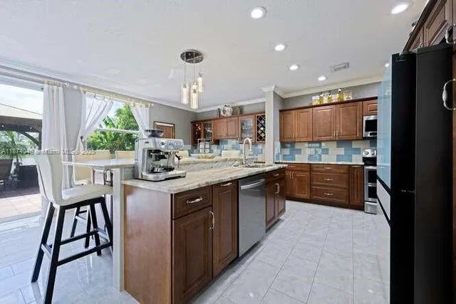 a kitchen with kitchen island granite countertop wooden floors and white cabinets