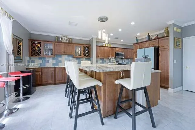 a kitchen with kitchen island a dining table and chairs