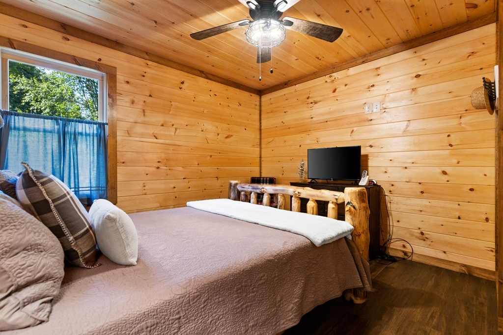 89 Whispering Hawk Trail Morganton, GA 30560 - Photo 21 of 33 a bedroom with a bed and a flat screen tv