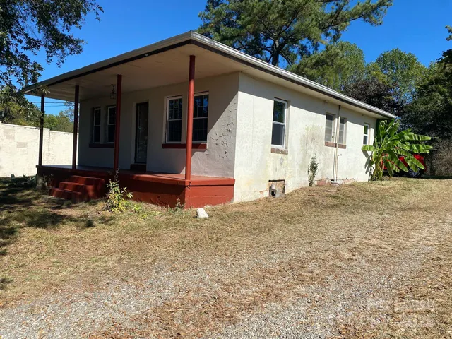 a backyard of a house with table and chairs
