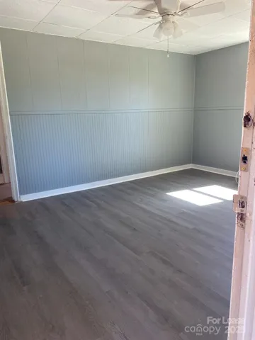 an empty room with a chandelier fan