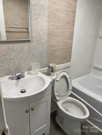 a bathroom with a sink a toilet and a mirror