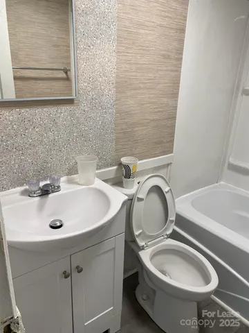 a bathroom with a sink a toilet and a mirror