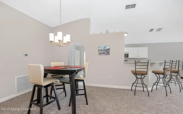 a view of a dining room with furniture and a chandelier