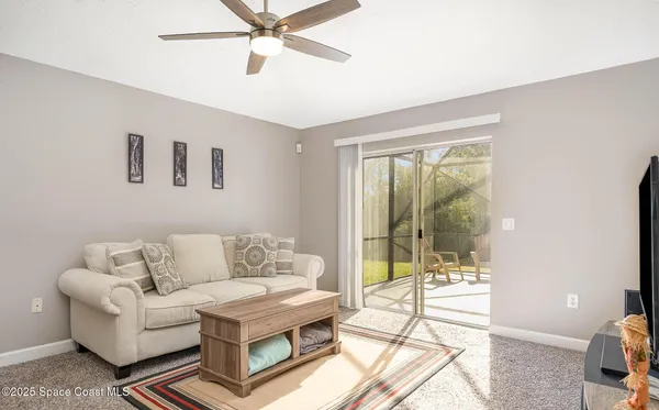 a living room with furniture and a floor to ceiling window