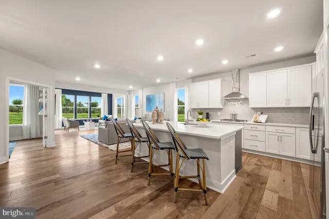 a living room with furniture and a dining table with wooden floor