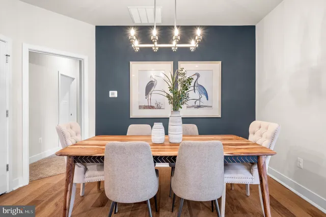 a view of a dining room with furniture a chandelier and wooden floor