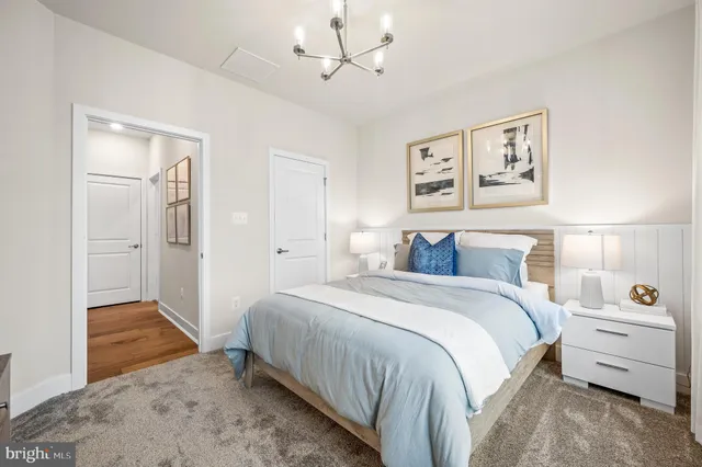 a spacious bedroom with a bed and a chandelier