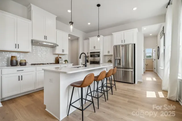 a large kitchen with stainless steel appliances granite countertop a stove and a sink