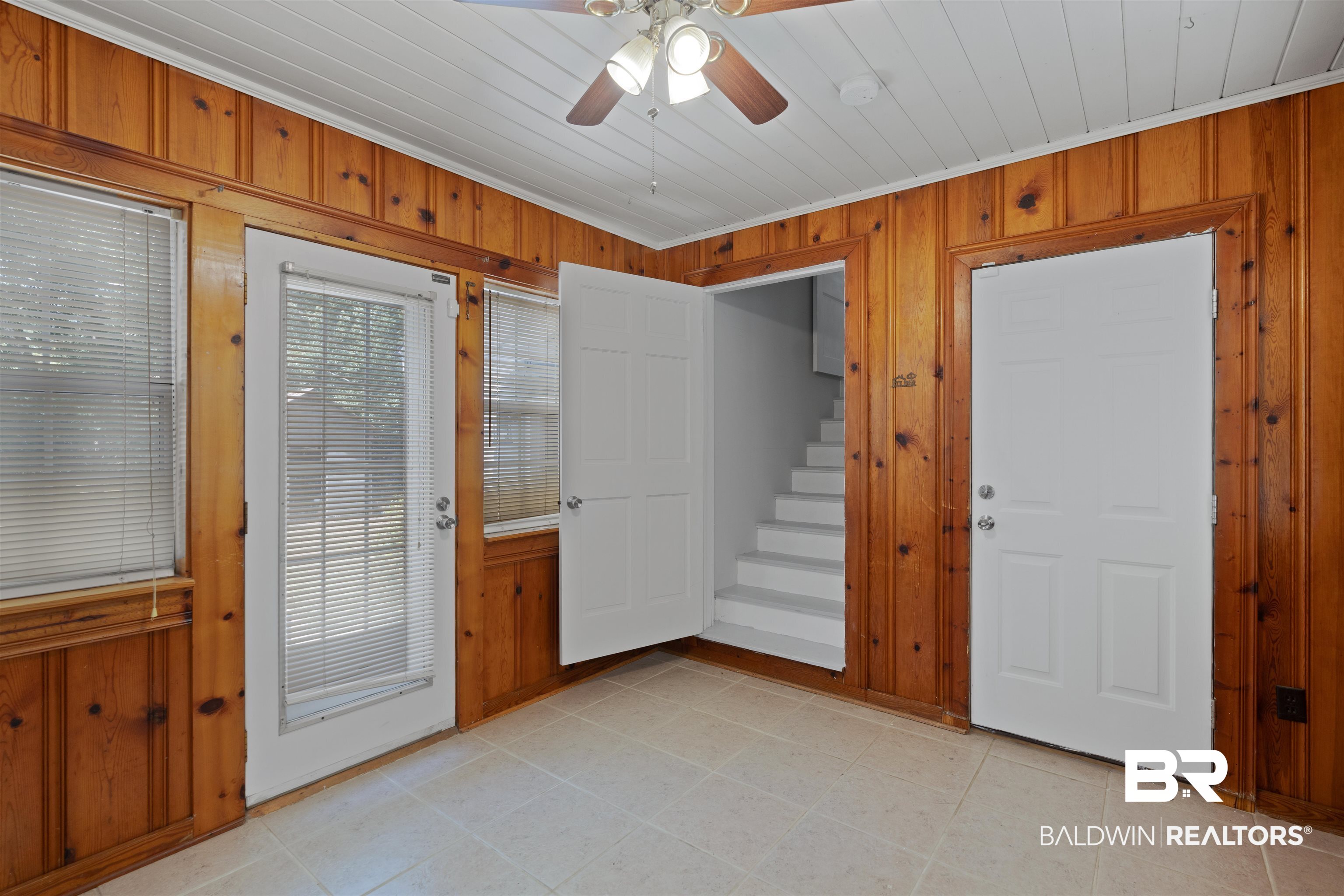 2126 Barron Place Mobile, AL 36605 - Photo 19 of 33 Doorway to outside with ceiling fan, wooden walls, light tile patterned flooring, and ornamental molding