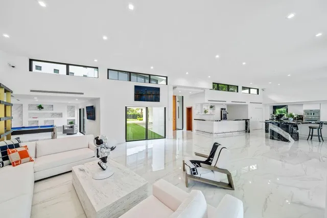 a living room with furniture stairs and a large window