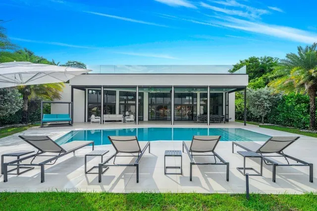 a view of a swimming pool with outdoor seating and plants
