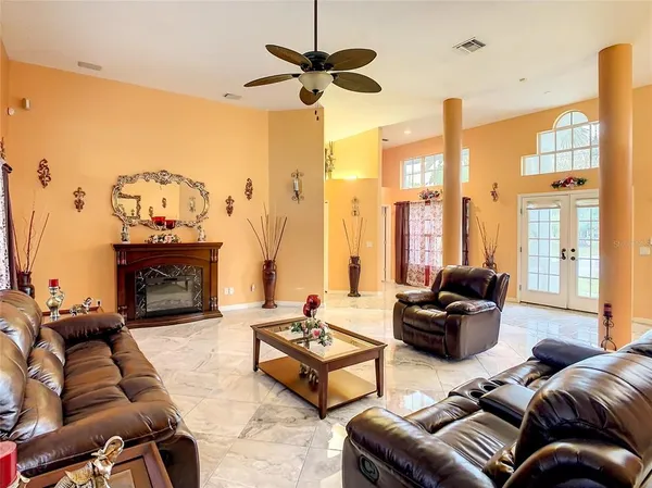 a living room with furniture a fireplace and a chandelier