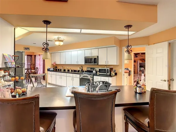 a kitchen with sink refrigerator dining table and chairs