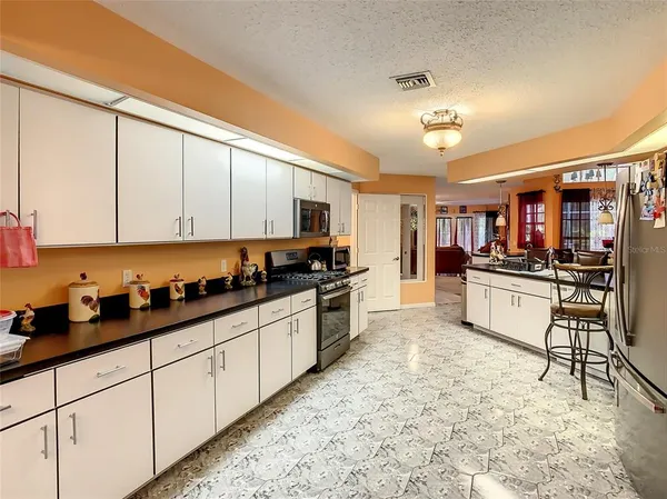 a kitchen with stainless steel appliances kitchen island granite countertop a stove a sink and a refrigerator