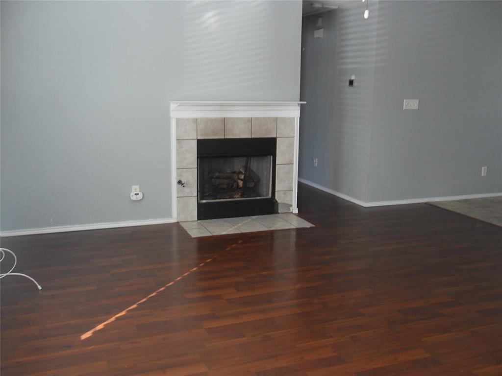 817 Cruise Street Denton, TX 76207 - Photo 2 of 17 a view of an empty room with wooden floor and a fireplace