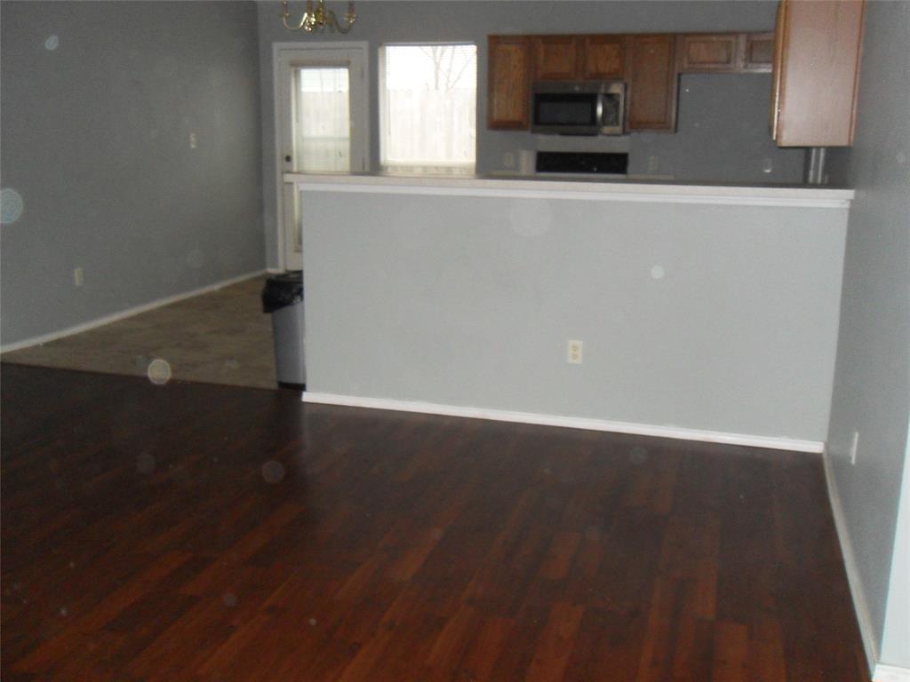 817 Cruise Street Denton, TX 76207 - Photo 3 of 17 an empty room with wooden floor and a window